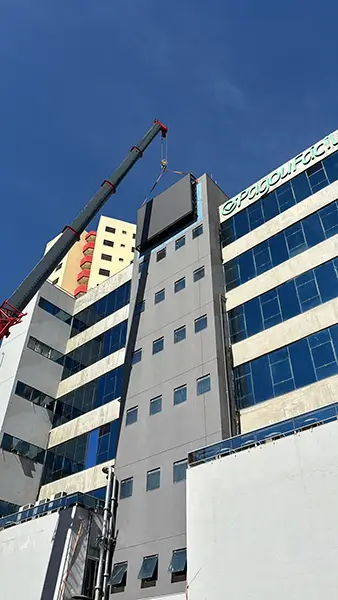 Large outdoor P5 LED screen installation process in Brazil showing crane lifting integrated cabinet structure.webp