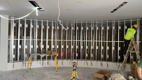 Curved steel frame installation and wiring for P4 flexible LED display wall.webp