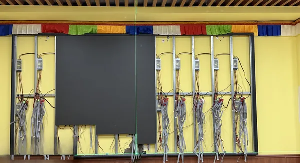 Steel sub-frame and wiring installed before LED module mounting in a high-altitude assembly hall.webp