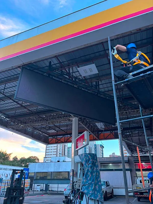 C。。。anopy mounted outdoor advertising display playing dynamic video content at gas station.webp